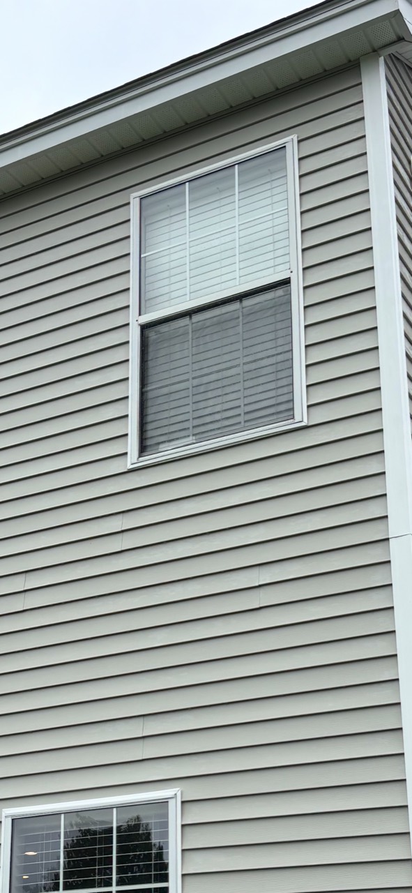 The same upper-story siding around a window after house washing